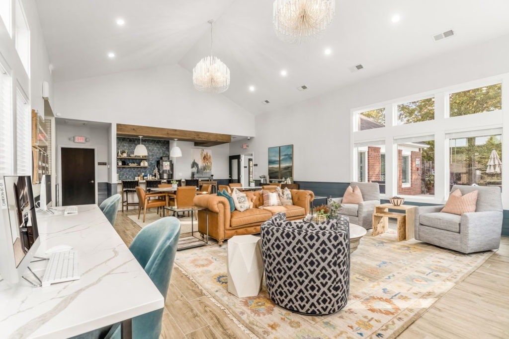 A modern living room with a white desk and a variety of seating options.