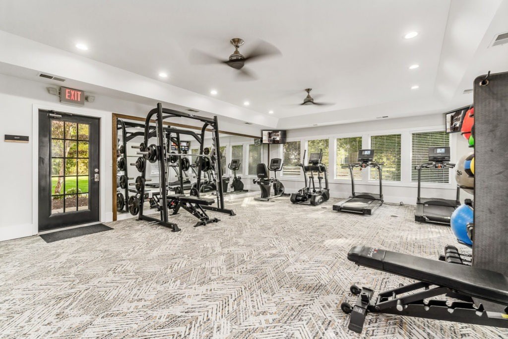 A gym with a variety of equipment including weights and treadmills.