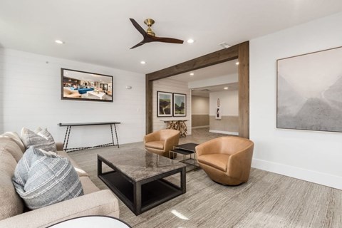 A living room with a grey couch, a coffee table, and a painting on the wall.