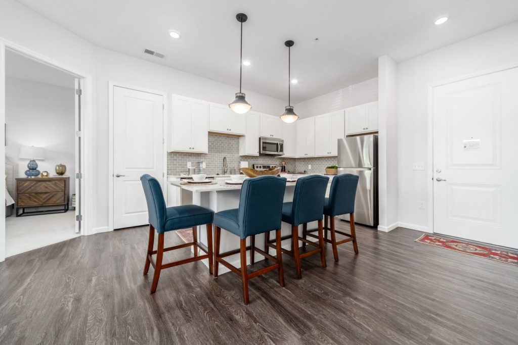 A kitchen with a table and chairs in the middle.