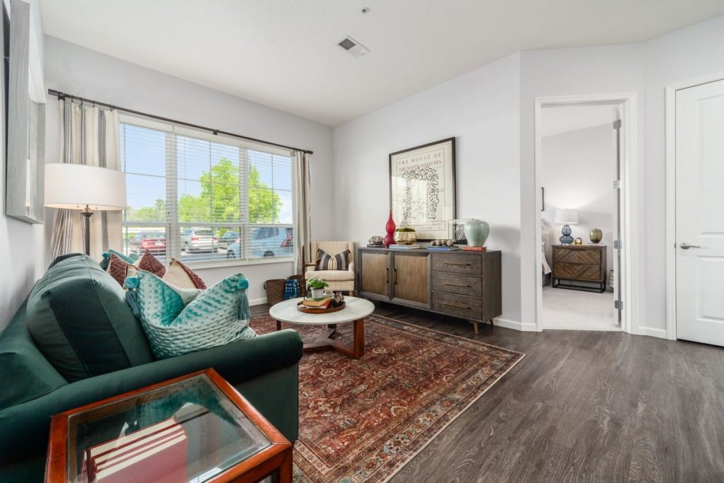 A living room with a green couch and a wooden coffee table.