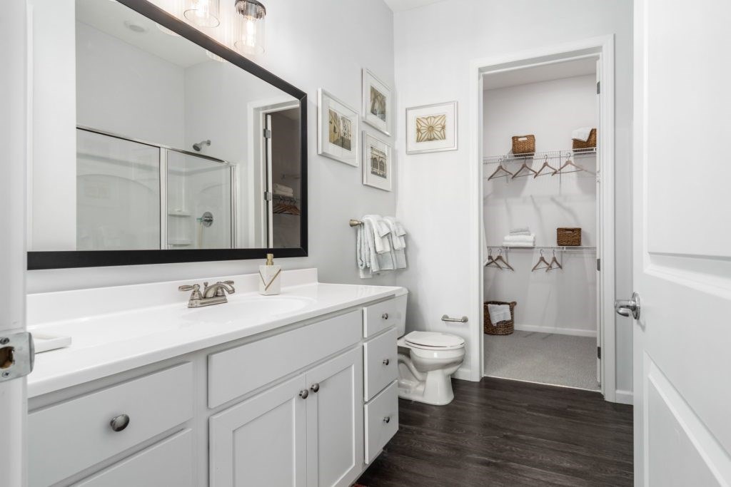 A white bathroom with a toilet and a mirror.
