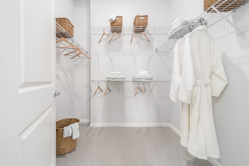 A white bathroom with a towel hanging on the wall.
