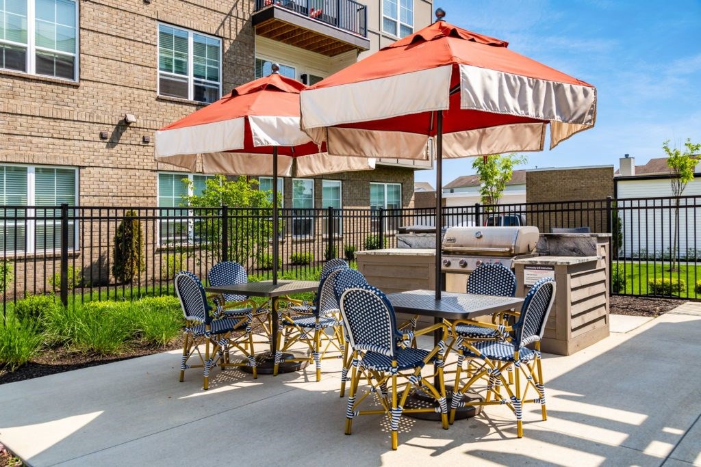 A patio with a table and chairs under an umbrella.