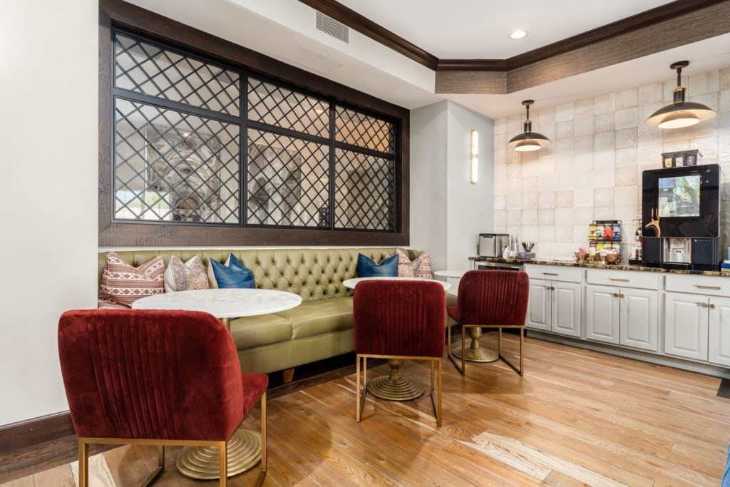 A living room with a green sofa, a red chair, and a wooden floor.
