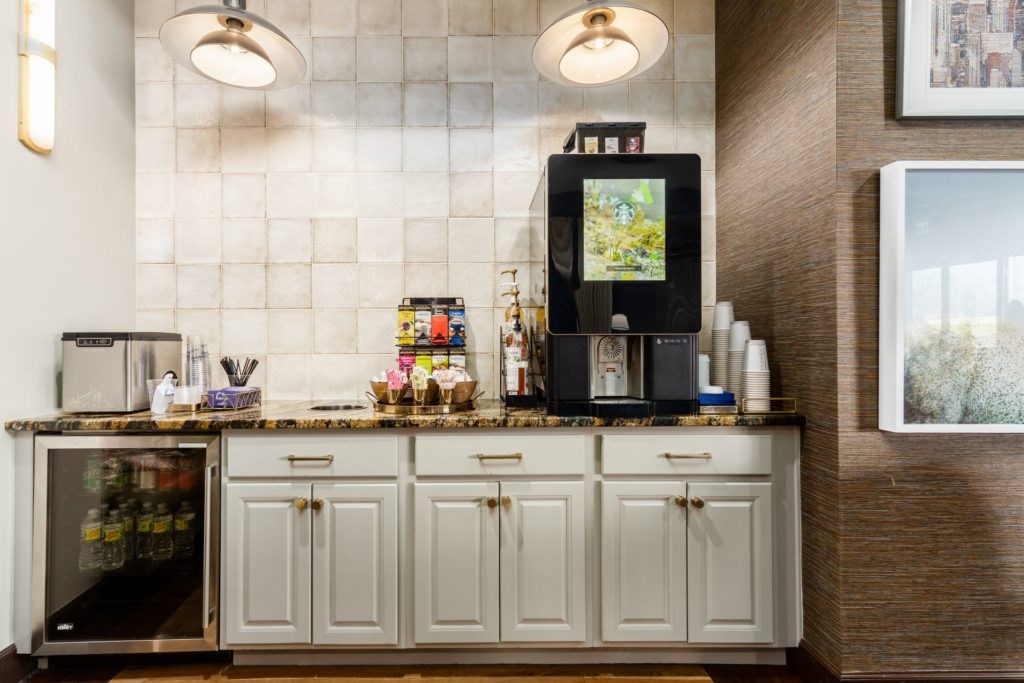 A kitchen with a refrigerator, cabinets, and a microwave.