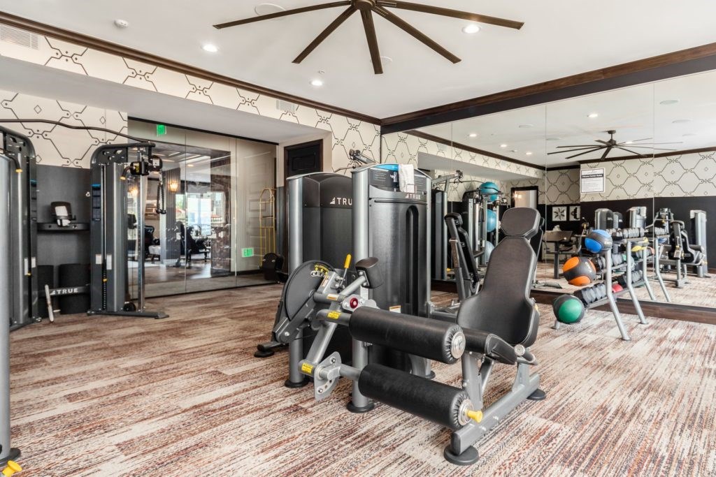 A gym with a variety of equipment including weights and cardio machines.