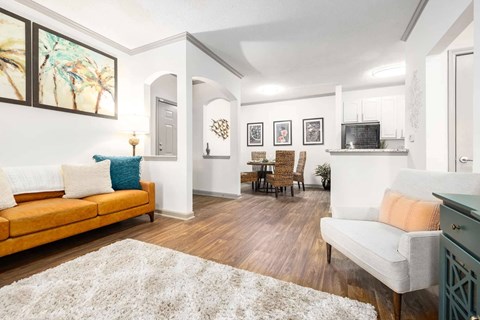 A living room with a white rug and a yellow couch.