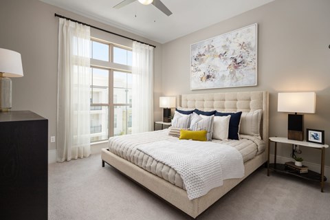 A bedroom with a large bed and a ceiling fan.