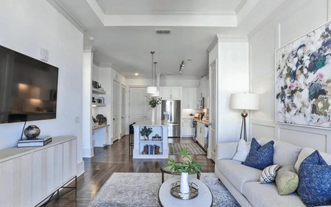 A living room with a grey couch and a television on the left side.