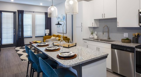 A modern kitchen with a dining table set for four.