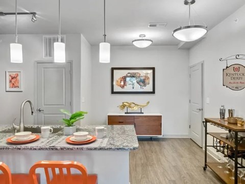 A kitchen with a table set for two and a painting of a horse on the wall.