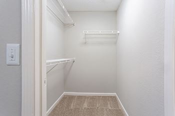 a walk in closet with shelves and a white door at Peaks at Gainesville, Gainesville, Georgia