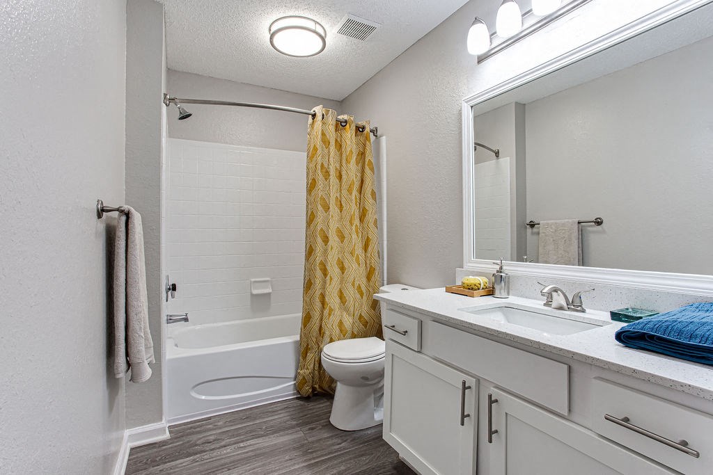 a white bathroom with a yellow shower curtain  at Peaks at Gainesville, Gainesville, GA