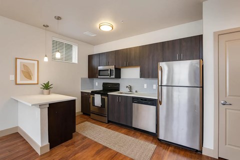 A kitchen with a refrigerator, microwave, and oven.