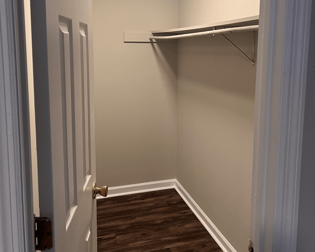 a small room with a closet and a door