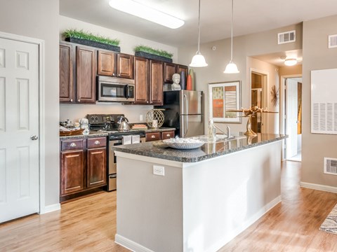 A kitchen with a white island and wooden cabinets.