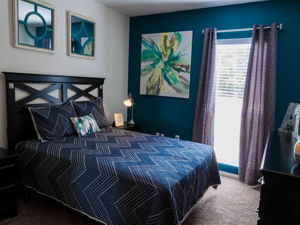 Spacious living room aith queen size bed and accent wall at the Grove at St. Andrews, Columbia, SC