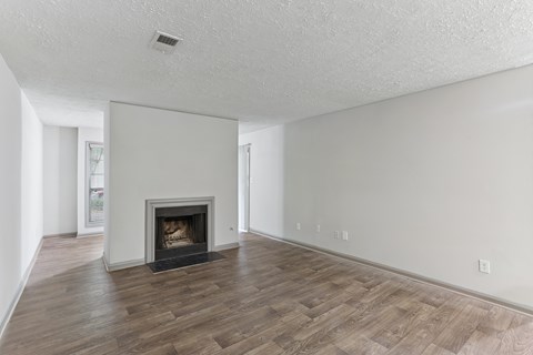 A living room with a fireplace and wood flooring.