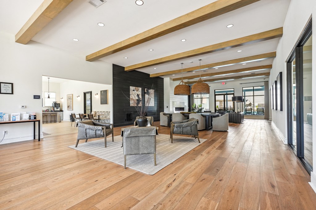 a large living room with chairs and tables and a fireplace