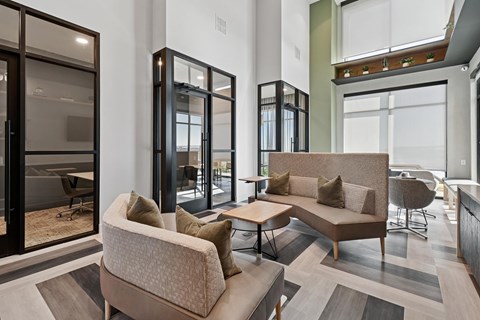 A modern living room with a large sofa and a glass door.