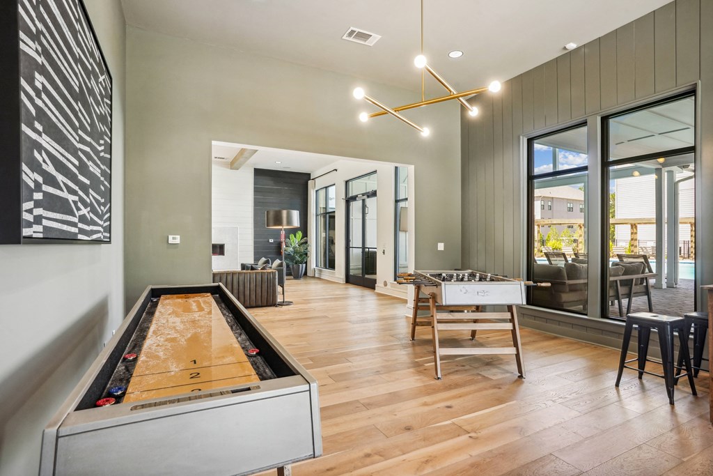 a living room with a ping pong table and a dining room table with chairs
