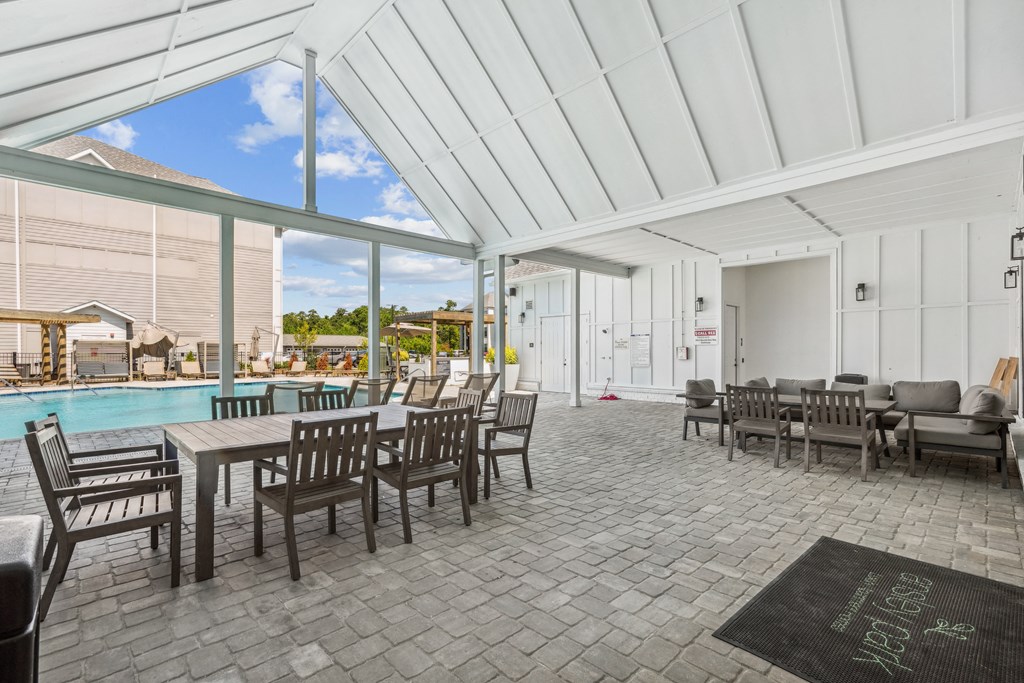 a patio with tables and chairs and a swimming pool