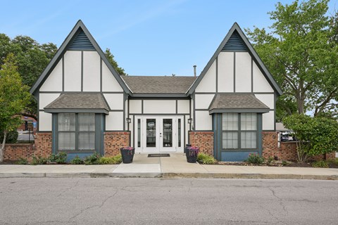 A white and black tudor style house with a grey front door.