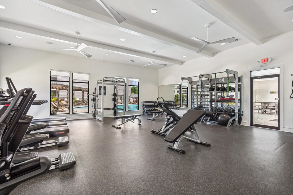 the gym with cardio equipment and weights at the apartments