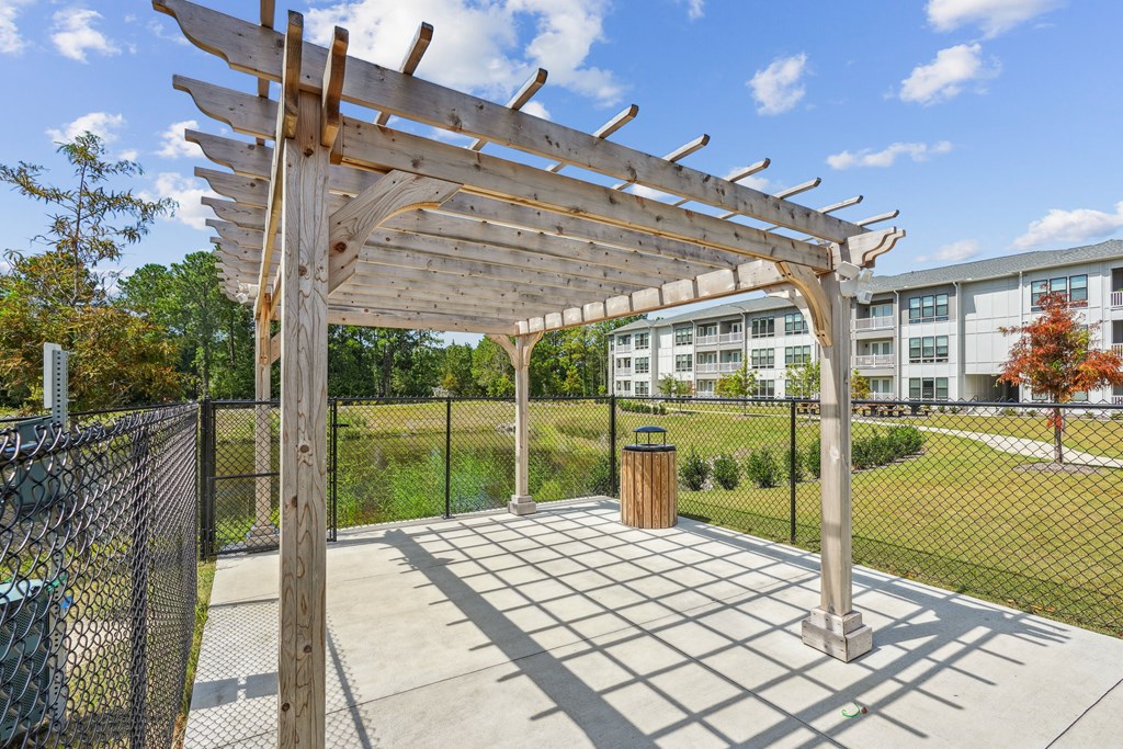 a pergola on a patio with a trash can
