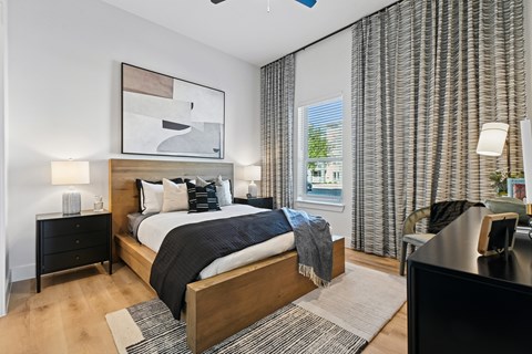 A bedroom with a large bed and a painting above it.