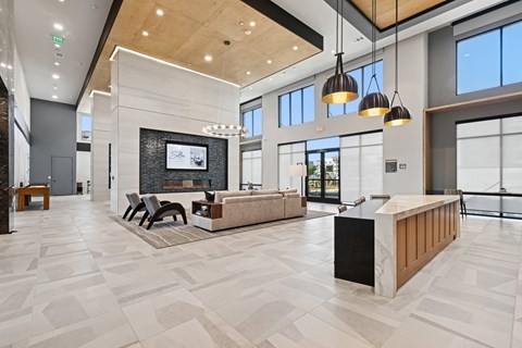 A spacious lobby with a fireplace and a reception desk.