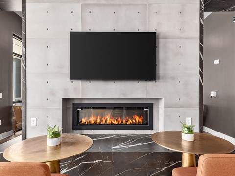 A modern living room with a fireplace and a flat screen TV mounted above it.