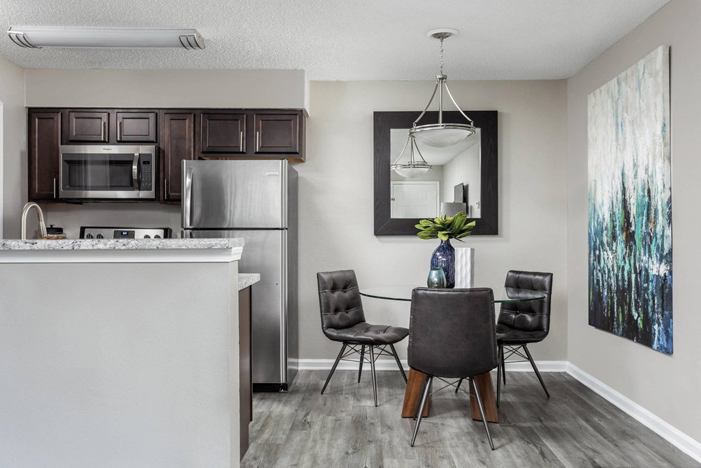 a kitchen and dining area with stainless steel appliances and a table and chairs