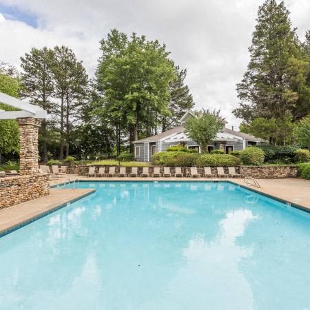 a large swimming pool with a house in the background