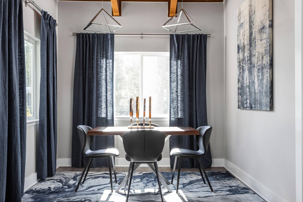 a dining room with a table and chairs in front of a window