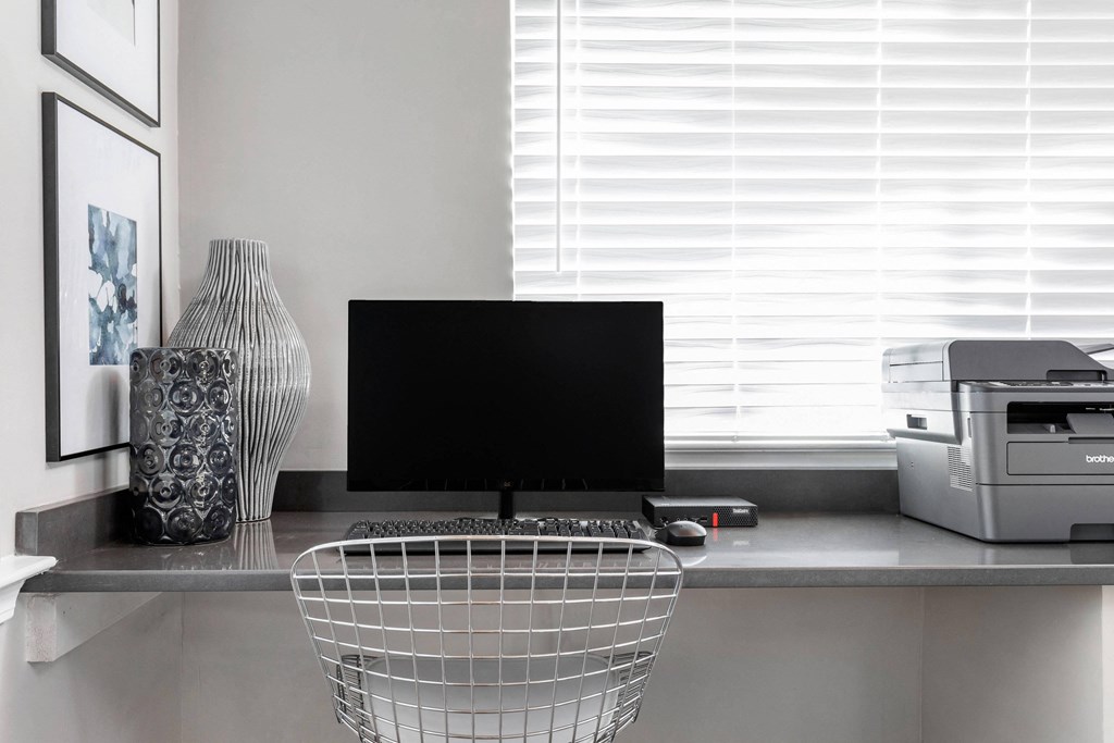 a home office with a computer and a printer on a desk