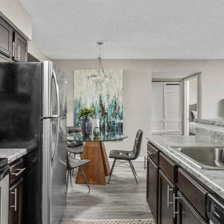 a kitchen with a refrigerator and a table and chairs