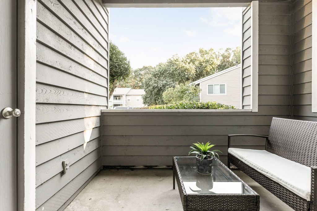 a porch with a couch and a table and a window