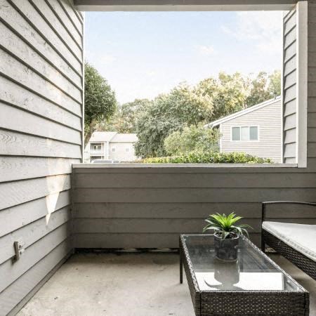 a balcony with a table and a plant on it