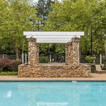 a swimming pool with a white gazebo next to a pool