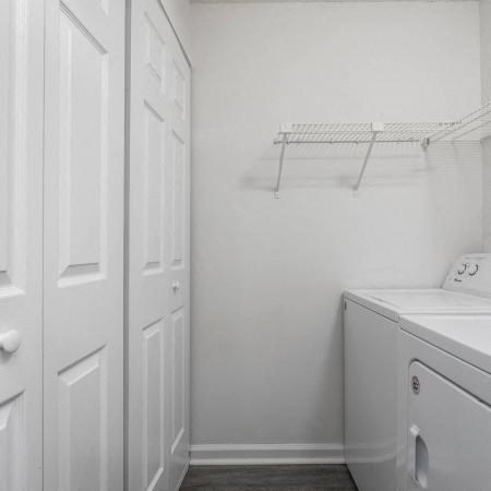 a white room with a washing machine and a closet