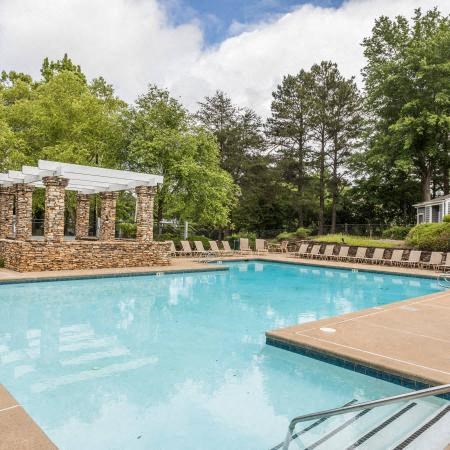 a large swimming pool with trees in the background