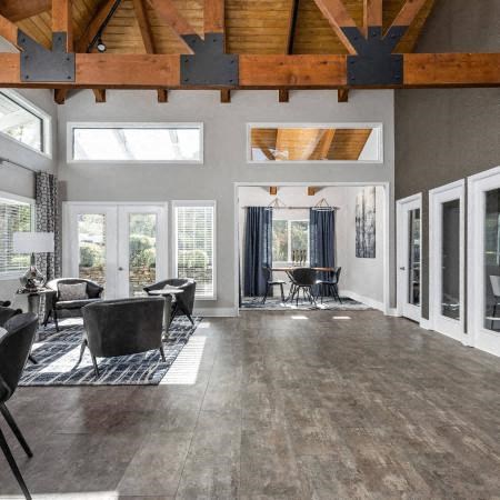 a large living room with a vaulted ceiling and large windows