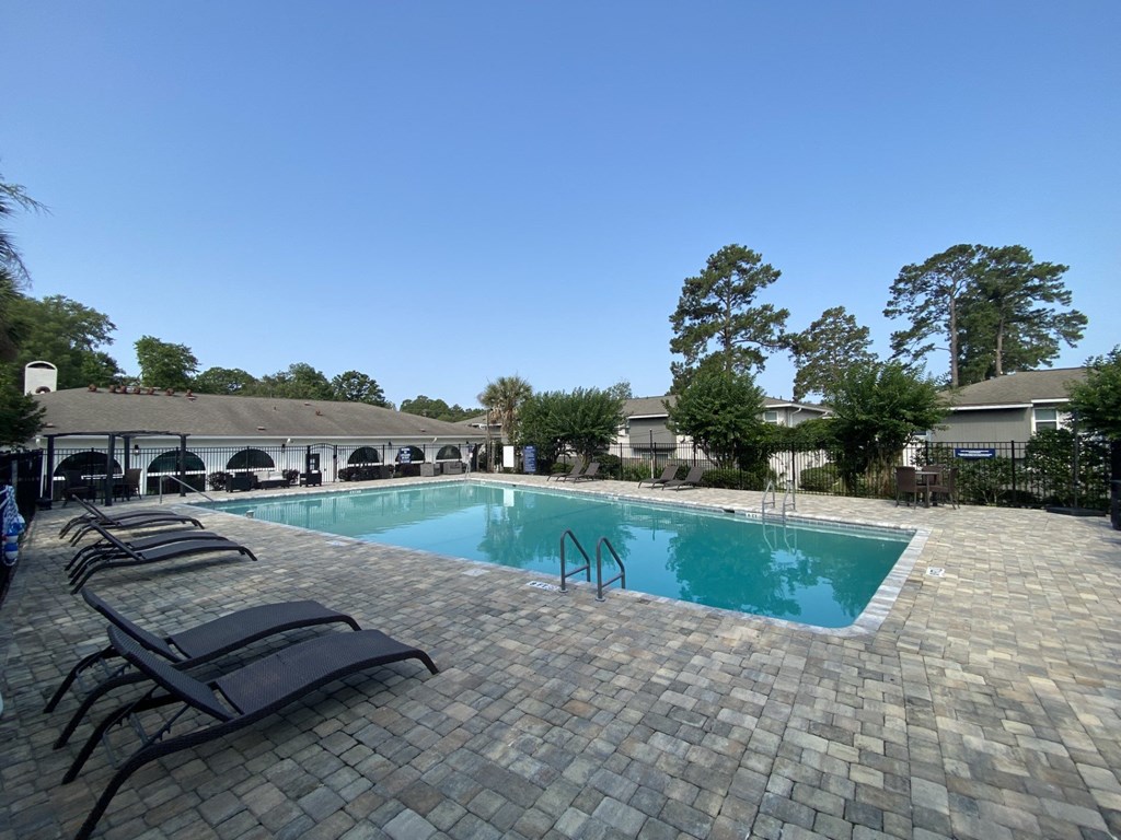 a resort style swimming pool with lounge chairs around it at Crescent Place Apartments, Georgia, 31419