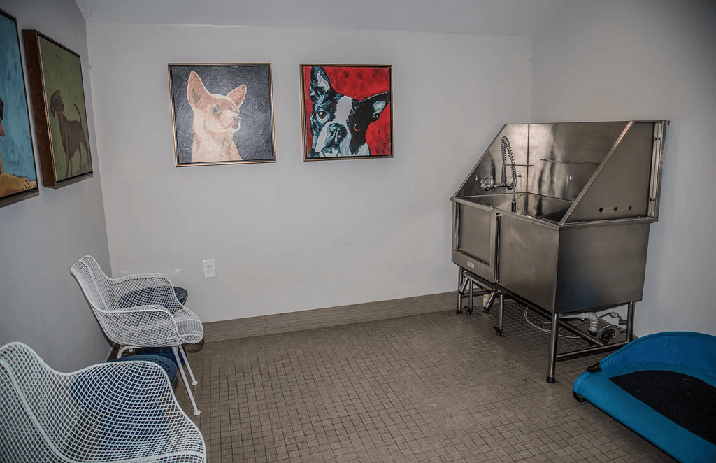 a room with a sink and chairs and a metal tub