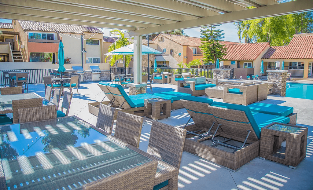 a patio with tables and chairs and a swimming pool