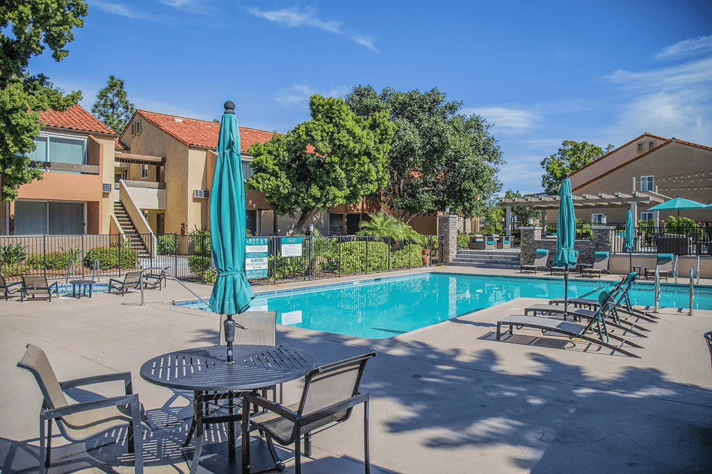 our apartments have a swimming pool with tables and chairs