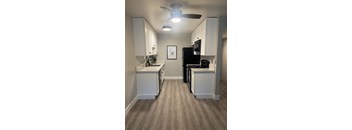 a kitchen with white cabinets and black appliances