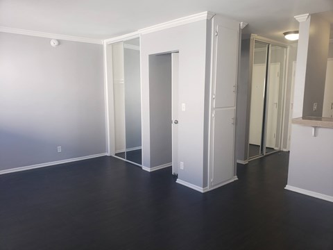 A room with a white door and a mirror on the wall.